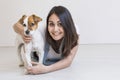 Beautiful young woman playing with her little cute dog at home. Lifestyle portrait. Love for animals concept. white background Royalty Free Stock Photo