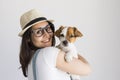 Beautiful young woman playing with her little cute dog at home. Lifestyle portrait. Love for animals concept. white background Royalty Free Stock Photo