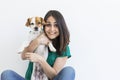 Beautiful young woman playing with her little cute dog at home. Lifestyle portrait. Love for animals concept. white background Royalty Free Stock Photo