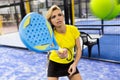 Beautiful young woman playing paddle tennis indoor.