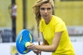 Beautiful young woman playing paddle tennis indoor.