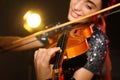 Beautiful young woman playing violin in dark room, closeup Royalty Free Stock Photo