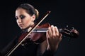 Beautiful young woman playing violin over black Royalty Free Stock Photo