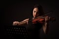 Beautiful young woman playing a violin over black background Royalty Free Stock Photo