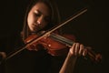 Beautiful young woman playing a violin over black background Royalty Free Stock Photo