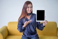 Beautiful young woman pointing finger and showing digital tablet computer on White board background .asian smiling girl Royalty Free Stock Photo
