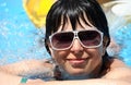 Beautiful young woman at a pool, in sunglasses