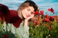 Beautiful young woman in poppy field. Woman on flowering poppy field. Summer holidays on nature. Girl on poppies meadow Royalty Free Stock Photo