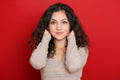 Beautiful young woman portrait with black long curled hair on red Royalty Free Stock Photo