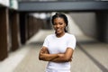 Beautiful young woman portrait in a city. Smiling african american girl with crossed arms looking at camera. People, business, Royalty Free Stock Photo