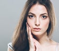 Beautiful young woman portrait cute tender pure smiling touching her cheek by palm attractive gray background Royalty Free Stock Photo