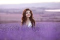 Beautiful young woman portrait in lavender field. Attractive brunette girl with long curly hair style enjoying life and dreaming. Royalty Free Stock Photo