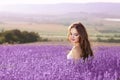 Beautiful young woman portrait in lavender field. Attractive brunette girl with long healthy hair style enjoying countryside life.