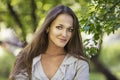 Beautiful young woman portrait next to a branch of a blossoming