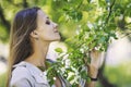 Beautiful young woman portrait next to a branch of a blossoming