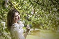 Beautiful young woman portrait next to a branch of a blossoming