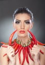 Beautiful young woman portrait with red hot and spicy peppers, fashion model with creative food vegetable make up Royalty Free Stock Photo