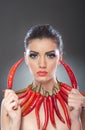 Beautiful young woman portrait with red hot and spicy peppers, fashion model with creative food vegetable make up Royalty Free Stock Photo