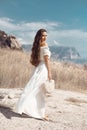 Beautiful young woman portrait in a white dress with woven handbag enjoying in the hay field. Natural beauty female. Romantic Royalty Free Stock Photo