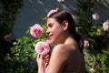 Beautiful young woman posing near roses in a spring garden. Candid lifestyle portrait of happy young beautiful sexy Royalty Free Stock Photo