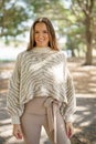 Beautiful young woman posing in the park an animal pattern sweater