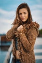 Beautiful young woman posing on the promenade at the river in the city