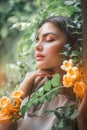 Beautiful young woman posing in Trumpet vine flowers in summer garden. Beauty model girl with Campsis. Enjoying nature Royalty Free Stock Photo