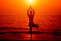 Beautiful young woman practic yoga at the beach. Early morning exercise Royalty Free Stock Photo