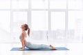 Beautiful young woman practices yoga asana Urdhva Mukha Svanasana - upward facing dog at the yoga class