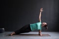 Young woman practices yoga asana Vasishthasana or side plank pose Royalty Free Stock Photo