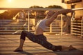 Beautiful young woman practices yoga asana Virabhadrasana 1 - warrior pose 1 in the terrace at sunset Royalty Free Stock Photo