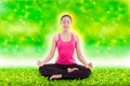 Beautiful young woman practicing yoga, sitting in a lotus position Royalty Free Stock Photo