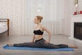 Beautiful young woman practicing yoga stretching on mat doing splits Royalty Free Stock Photo