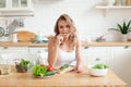 Beautiful young woman is preparing vegetable salad in the kitchen. Healthy Food. Vegan salad. Diet and dieting concept. Royalty Free Stock Photo