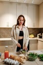 Beautiful young woman preparing vegetable vegan salad in the kitchen. Healthy food and diet concept lifestyle. Cook at home Royalty Free Stock Photo