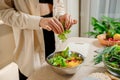 Beautiful young woman preparing vegetable vegan salad in the kitchen. Healthy food and diet concept lifestyle. Cook at home Royalty Free Stock Photo