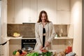 Beautiful young woman preparing vegetable vegan salad in the kitchen. Healthy food and diet concept lifestyle. Cook at home Royalty Free Stock Photo