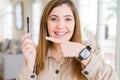 Beautiful young woman putting lash mascara on eyelashes very happy pointing with hand and finger Royalty Free Stock Photo