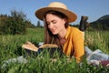 Beautiful young woman reading book on green meadow Royalty Free Stock Photo