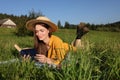 Beautiful young woman reading book on green meadow Royalty Free Stock Photo