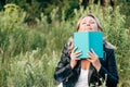 Beautiful young woman reading a book on the lawn with the Sun