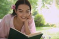 Beautiful young woman reading book in park on sunny day Royalty Free Stock Photo