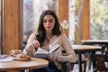 Beautiful young woman reading a book while sitting at the cafe Royalty Free Stock Photo