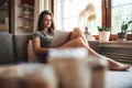 Beautiful young woman reading book on sofa in living room at home Royalty Free Stock Photo