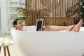 Beautiful young woman reading book while taking bath at home Royalty Free Stock Photo