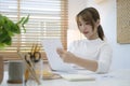 Beautiful young woman reading an important document, working at home office Royalty Free Stock Photo