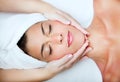 Beautiful young woman receiving facial massage. Royalty Free Stock Photo