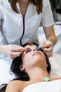 Beautiful young woman receiving gemstone therapy in spa. Royalty Free Stock Photo