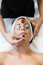 Beautiful young woman receiving gemstone therapy in spa. Royalty Free Stock Photo