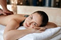 Beautiful young woman receiving massage in spa salon. Body care. Spa body massage woman hands treatment. Royalty Free Stock Photo